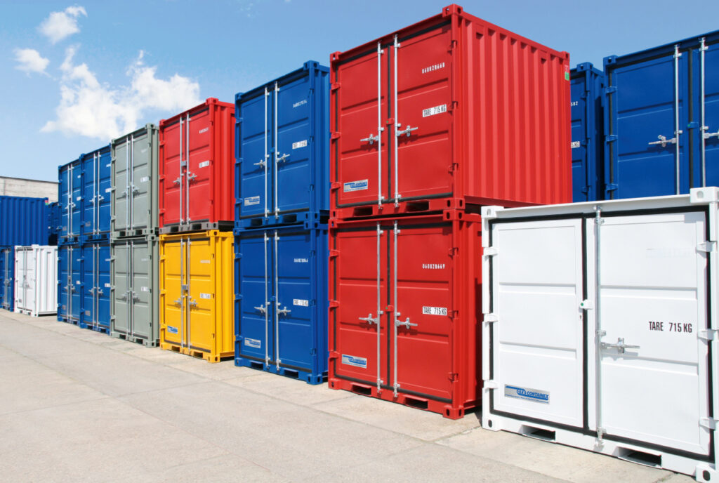 Container af typen lagercontainere fra Containex. Stablet og i forskellige farver: blå, rød, hvid, grå og gul