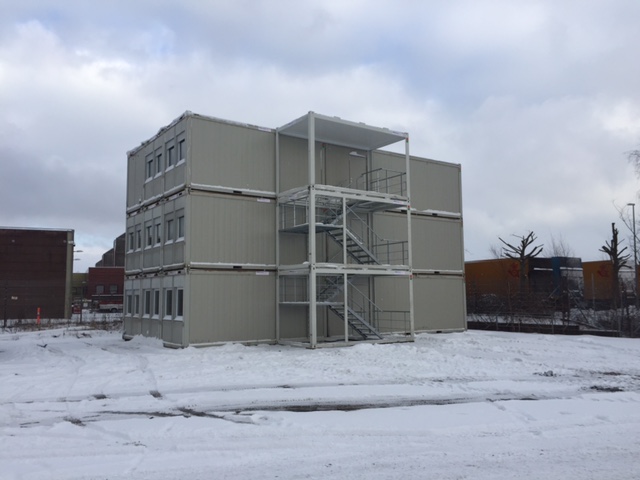 Byggepladskontor opstillet for Råhus Construction i Aalborg af PRO-trans A/S. Bygningen er sammensat af 21 stk kontorcontainere. 3 stk 24' i midten, samt 9 stk. 20' i hver gavl. På billedet ses den færdigt opstillede bygning udefra.