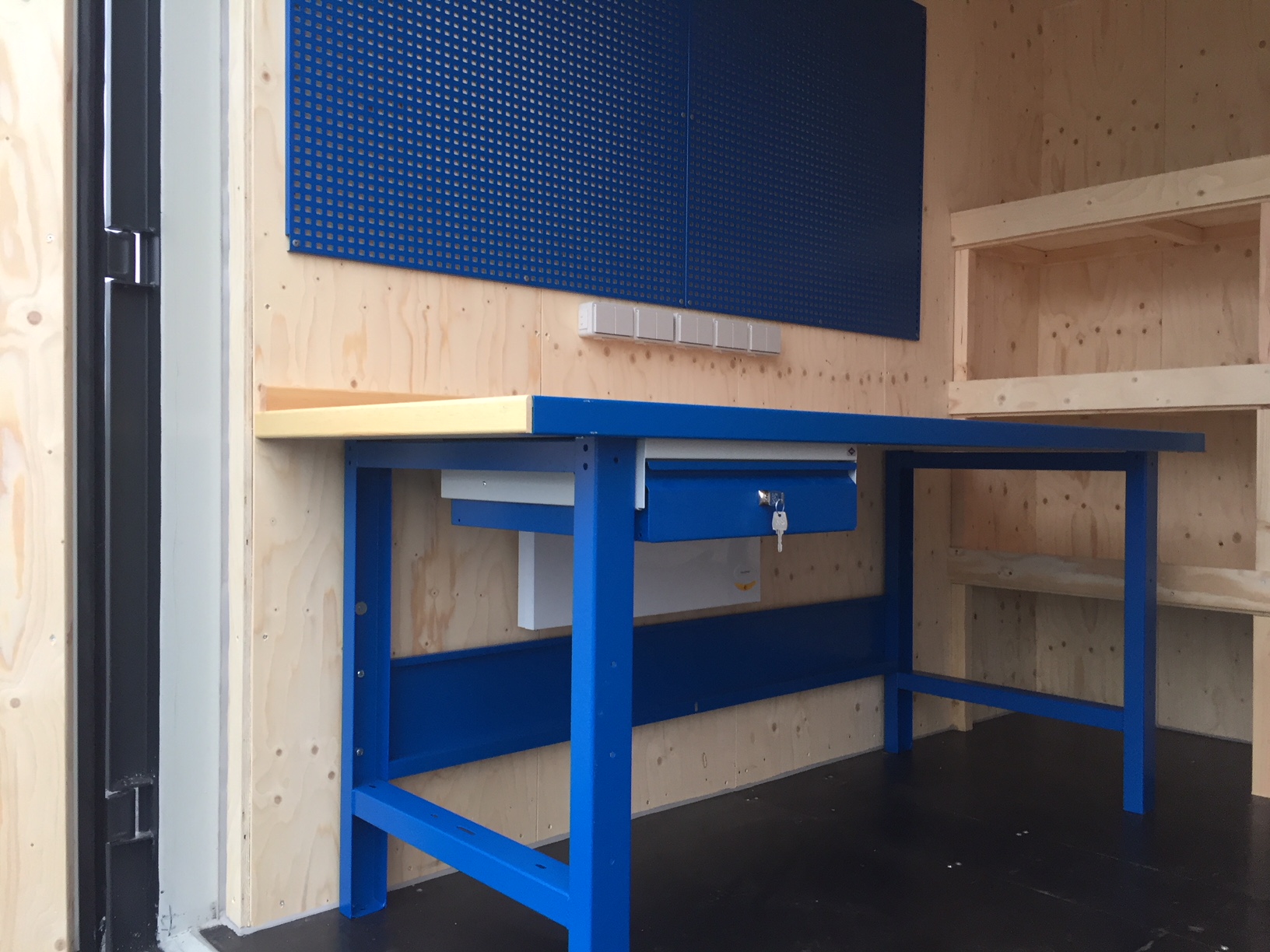 Arbejdsbord i isoleret materialecontainer. Der er radiator under bordet og mulighed for diverse el tilslutninger.